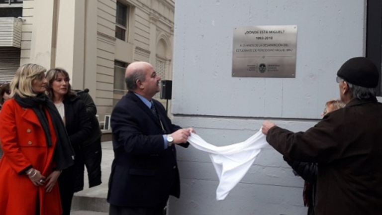 El presidente de la UNLP destapando la placa conmemorativa hacia el estudiante desaparecido Miguel Bru