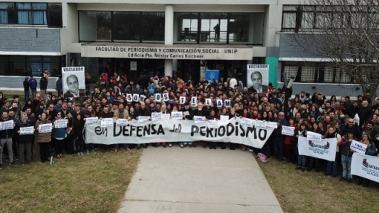 Fachada de la Facultad con todos/as exigiendo la libertad de expresión y el derecho a la comunicación