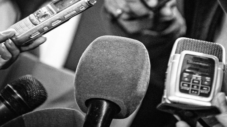Foto de micrófonos en blanco y negro en alusión al Día del trabajador de Prensa