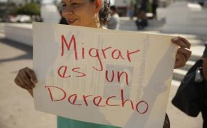 persona sosteniendo un cartel que dice migrar es un derechos