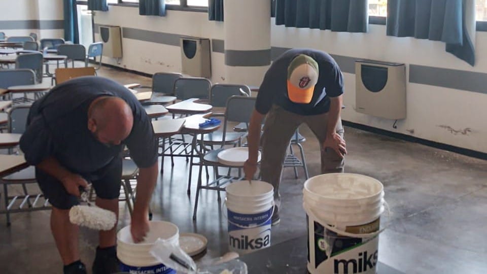 dos personas trabajando con pinturas en un aula de la Facultad
